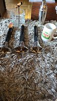 Three pint pull handles, Labatts 50 mug, glass ice bucket, shaker, corkscrew arranged on carpet.