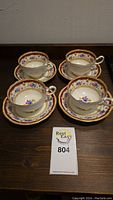 Four teacups displayed on matching saucers, front view