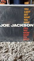Joe Jackson vinyl album cover with title 'You Can't Get What You Want (Till You Know What You Want)' in white and orange text on a black background.