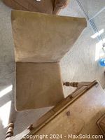 Top view of beige upholstered chair seat and backrest with wooden legs visible