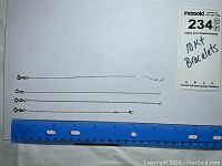 Four thin 10Kt gold bracelets laid out next to a ruler showing length around 6 to 7 inches. One bracelet has a broken clasp.