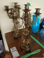 Pair of brass candelabras, front view showing the 5-arm and 3-arm candle holders with intricate ornate design, standing approximately 16 inches tall.