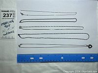Five sterling silver chain necklaces laid out alongside a ruler showing lengths approximately 16", 18", and 20". One chain has a heart-shaped pendant and one chain appears damaged.
