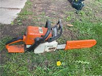 Left side view showing full chainsaw with guide bar and protective scabbard