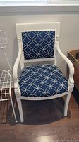 Front view showing full chair with armrests, seat and backrest upholstered in blue fabric with white circular pattern.