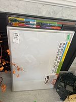 View of the magnetic dry erase board in packaging, showing the whiteboard and marker set including eraser.