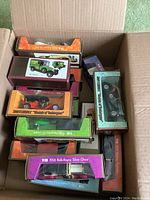 Photo of an open box containing multiple boxed vintage Matchbox Models of Yesteryear vehicles showing some cars and box art