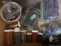 Drawer with assorted screws and bolts in plastic containers and zip-lock bags.
