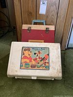Closed Winnie the Pooh record player case showing the colorful Pooh and Tigger label on top with handle and latch clasps.