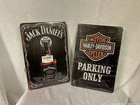 Two metal signs brand new, one Jack Daniels Old No 7 with bottle, one Harley-Davidson parking only black vintage style.
