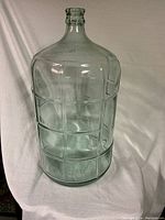 Clear glass carboy about 22 inches tall with smooth finish and no visible damage.