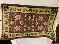 Top view of the small rug showing the central medallion and border design with floral and geometric patterns.