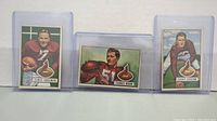 Four 1951 Bowman Chicago Cardinals football cards displayed upright in protective plastic sleeves, showing players Elmer Angsman, Thomas Wham, and Jerry Groom.