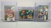 Three football cards in plastic cases: Eddie Price, Donald Doll, Ross Craft.
