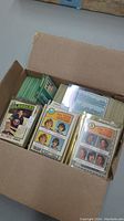 Open cardboard box filled with stacks of green-backed O-Pee-Chee hockey cards and Team Leaders cards at front