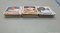 Three stacks of baseball cards laid flat showing Dick Drago, Fernando Arroyo, Al Cowens cards on top respectively.