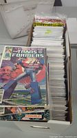 Long white longbox filled with bagged and boarded comics, front issue Marvel’s Transformers #1 visible