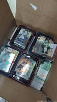 Box of football cards with four trays showing cards of NFL players including one with a holographic effect