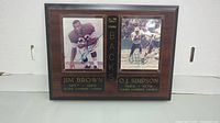 Full front view of the wooden plaque showing Jim Brown and O.J. Simpson photos side by side with inscriptions and signature.