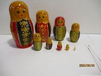 All nine Russian nesting dolls arranged in a row from largest to smallest showing their scale and design details.