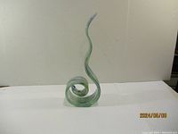 Side view of the art glass sculpture showing its tall spiral design and smooth finish