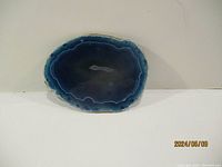 Front view of polished blue agate geode slab with banding and crystal center.
