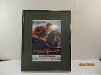Full view of framed Goldfinger movie poster print with green mat and simple frame, showing classic James Bond artwork with Sean Connery.