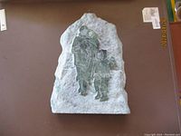 Front view of the Inuit stone carving showing an adult with two children dressed in traditional clothing.