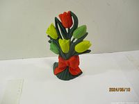Front view of metal tulip flower door stop with colorful paint and red bow