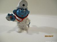 Front view of the vintage Smurf doctor figurine with stethoscope and head mirror