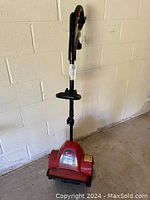 Front view of Toro power shovel showing the red base, handle, and grip.