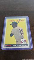 Front of 1958 Topps baseball card featuring Valmy Thomas in San Francisco Giants uniform batting pose with bright yellow background.