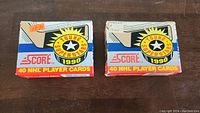 Two sealed 1990 Score Young Superstars hockey card boxes on a dark surface, showing front facing graphics and vintage price tags.