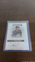 Front of the autographed Jack Roslovic hockey card showing the player image, authentication number, and signature.