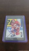 Front side of Theoren Fleury Pinnacle hockey card showing player in Calgary Flames uniform with autograph clearly visible in blue ink.