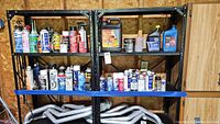 Shelves with assorted automotive fluid containers, mostly spray cans and plastic bottles.