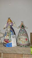 Photo showing both Jim Shore angel figurines on a shelf, with one measuring 10 inches tall alongside a lot tag