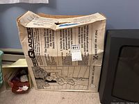 Image showing folded ladder box with printed emergency ladder usage instructions and illustrations on beige packaging.