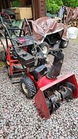 Front angled view of Toro snow blower on gravel ground showing chute, auger, and control panel