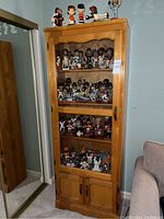 Full view of wooden cabinet filled with Giants bobbleheads from top to bottom
