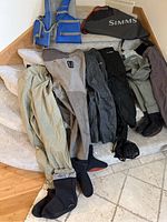 Overall view of life jacket, chest waders, pants and carry bag on stairs