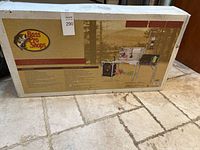 Photo of unopened box of Bass Pro Shops Deluxe Camp Kitchen showing product branding and general size.
