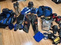 Overall overview of dirt bike gear including boots, pants, jerseys, helmet, protective gear and bag