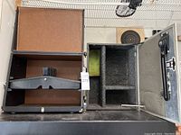 Open black hard case showing interior compartments and dividers.