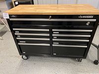 Closed Husky tool chest with butcher block top and visible drawer arrangement on casters