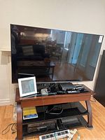 Front view of LG TV on stand with accessories