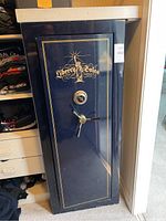 Front view of dark blue Liberty Safe showing exterior, gold logo, combination dial and handle