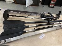 Metal detector handle, lower pole, and several paddle attachments displayed on table.