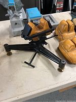 Full view of black cast-iron rifle rest with leather front cradle and rear bag