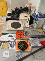 Overview of table with paper targets, bipod mounts, ear protection and manuals